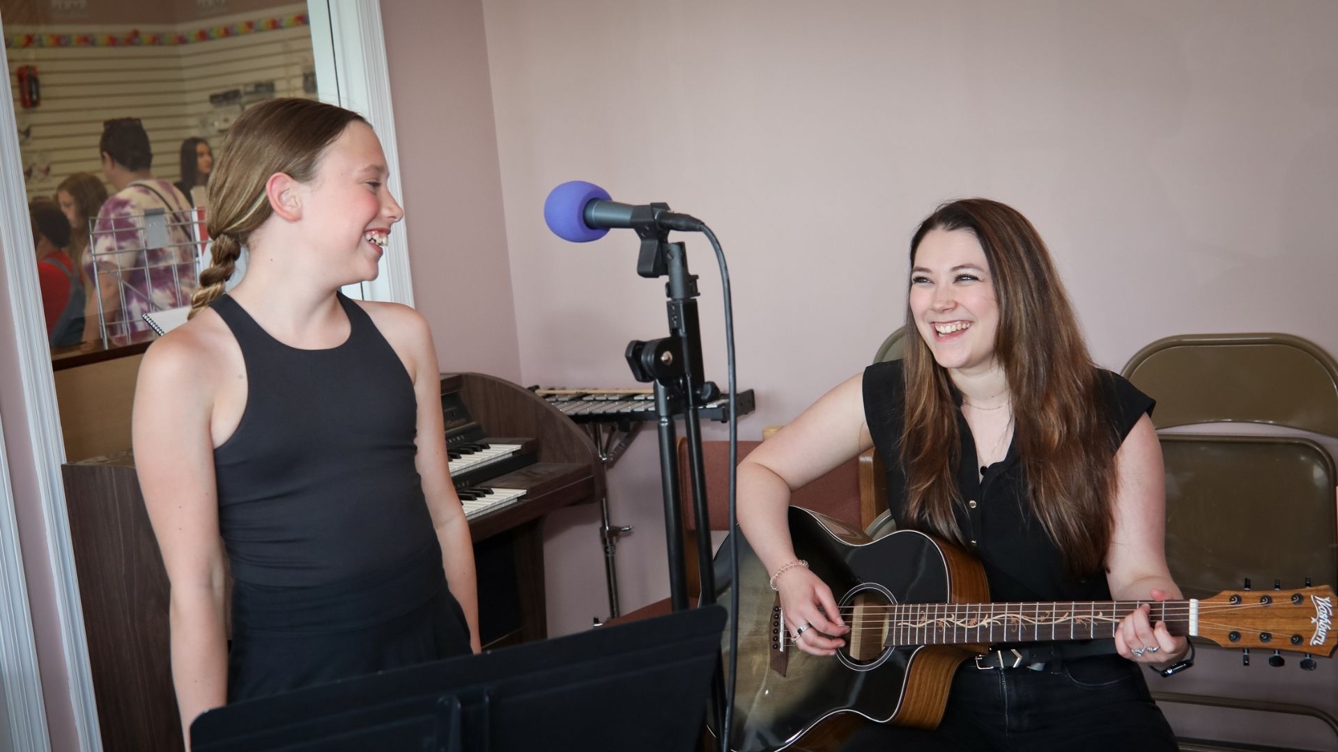 guitar teacher and vocal student in a lesson together