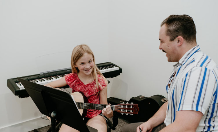 teacher and student learning guitar