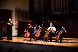 String ensemble with pianist and instructor on stage