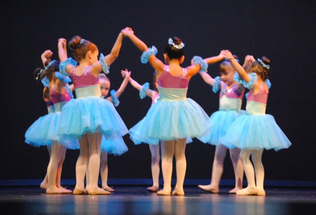young ballerinas holding hands in a circle