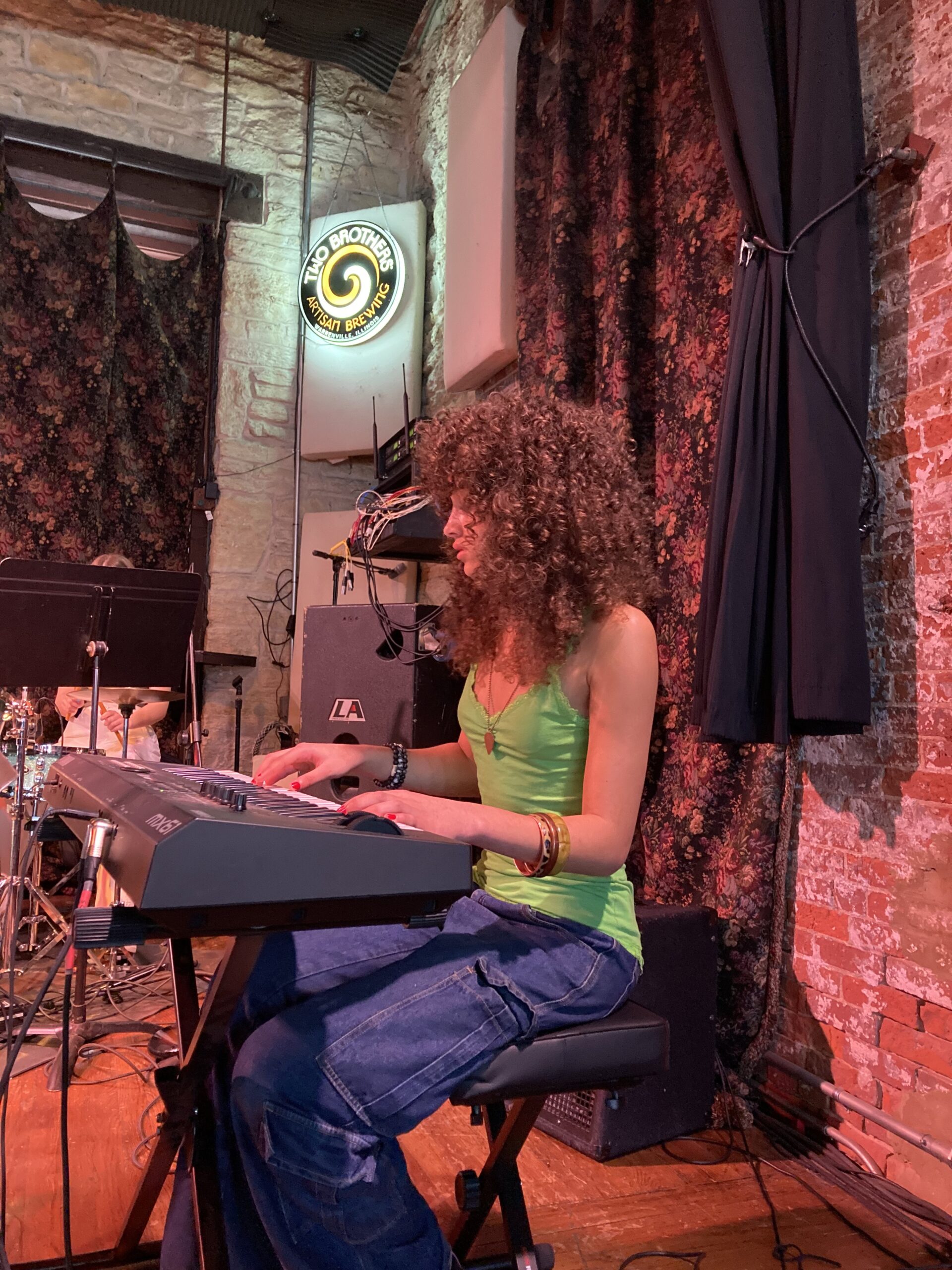 girl in a green shirt playing piano on stage